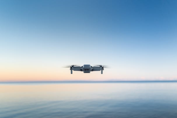drone flying over the ocean at sunset