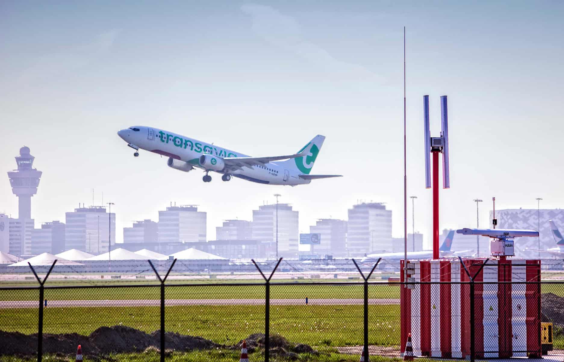 Commercial aeroplane taking off from Schiphol airport, with the skyline in the background