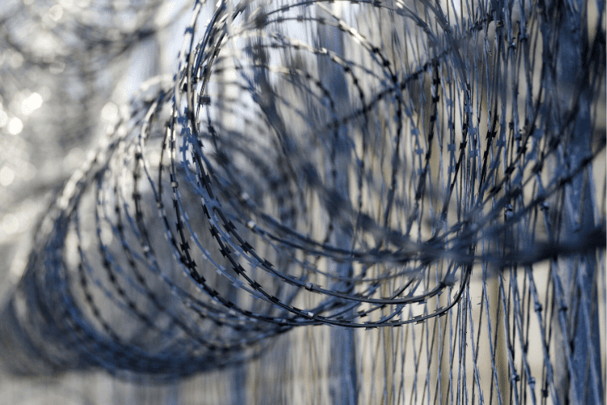 Chain link prison fence topped with razor wire - an ineffective defence against the drone prison security threat