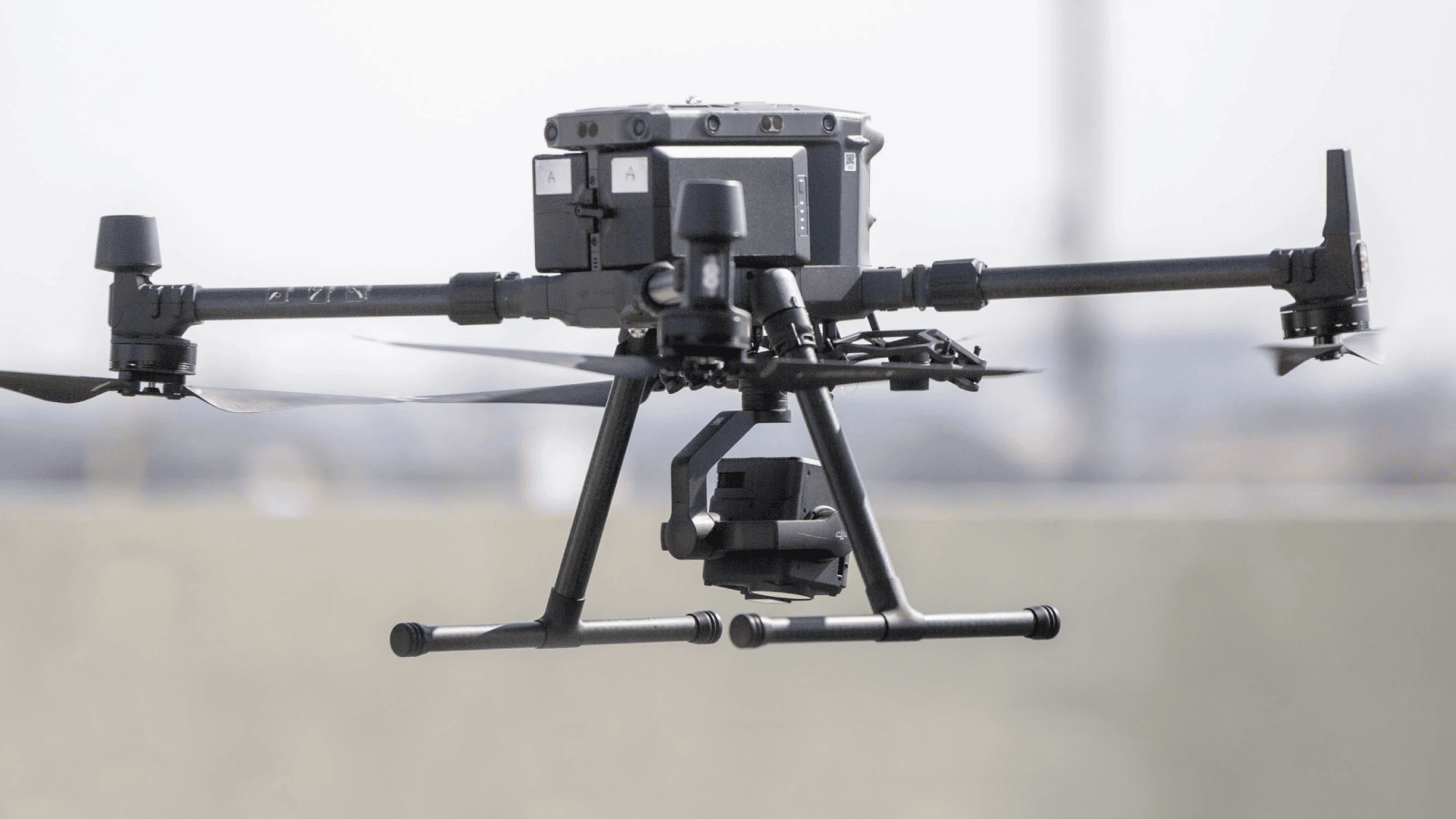 Close up of a dark gray drone, hovering